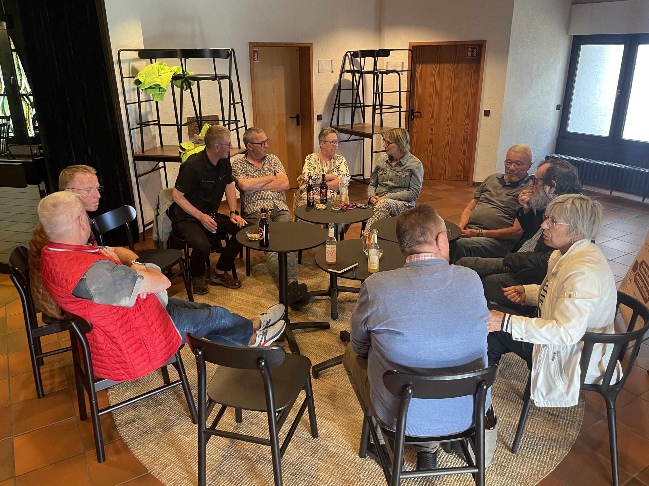 Menschen sitzen in einem Stuhlkreis und unterhalten sich